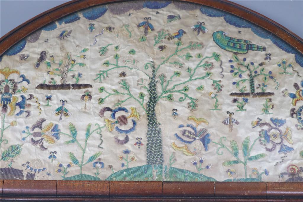 A late 17th century silk and bead work arched panel, width 22.5in. height 11.75in.